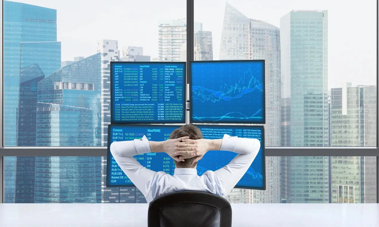 Trader analyzing stock data on screens